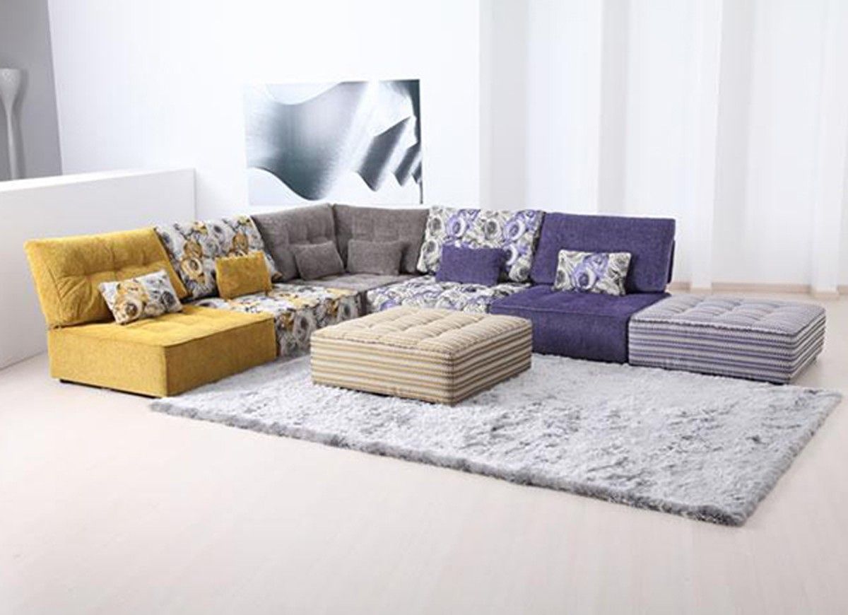 Modular sectional sofa with yellow, gray, and purple sections on a shaggy rug.