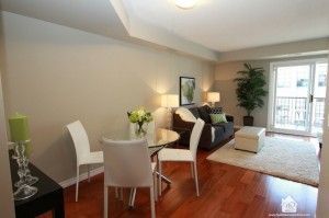 Modern open-concept living and dining area with hardwood floors and balcony access.