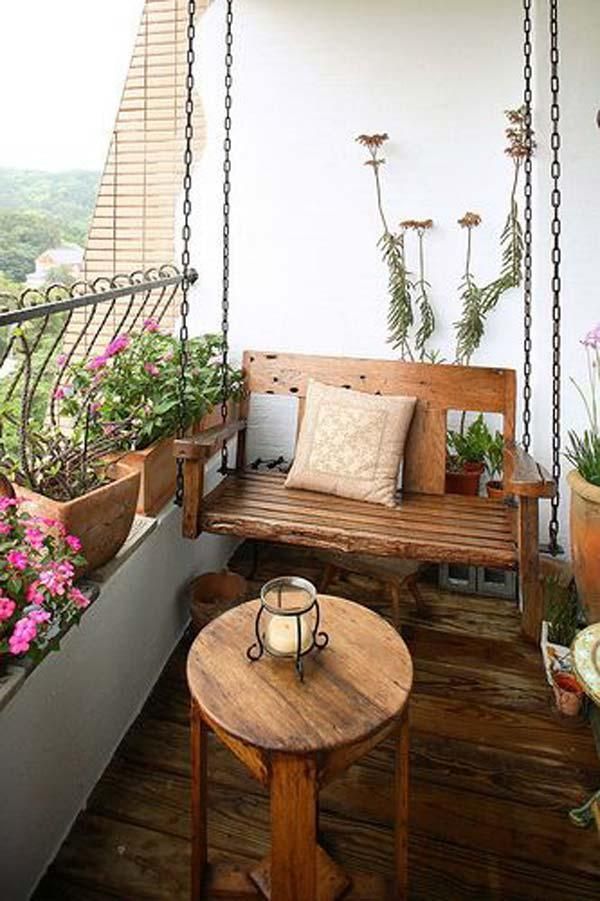 Cozy balcony with a wooden bench, potted plants, and small table with a candle.