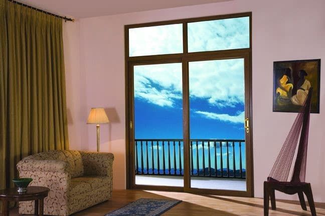 Interior room featuring a large sliding glass door with a stunning blue sky and ocean view.