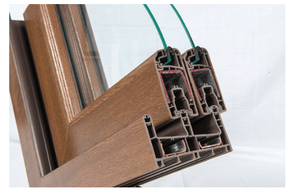 Cross-section of a brown window frame showing multi-chambered profile and double glazing.
