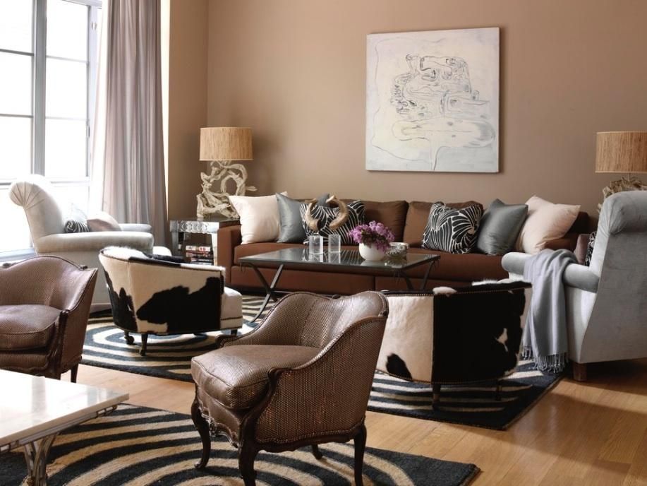 Spacious living room with brown sofa, assorted chairs, and stylish black and white circular rugs.