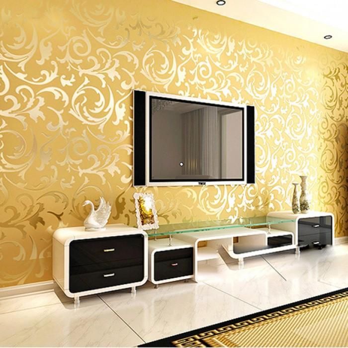 Modern living room with gold ornate wallpaper, large flat-screen TV, and sleek media console.
