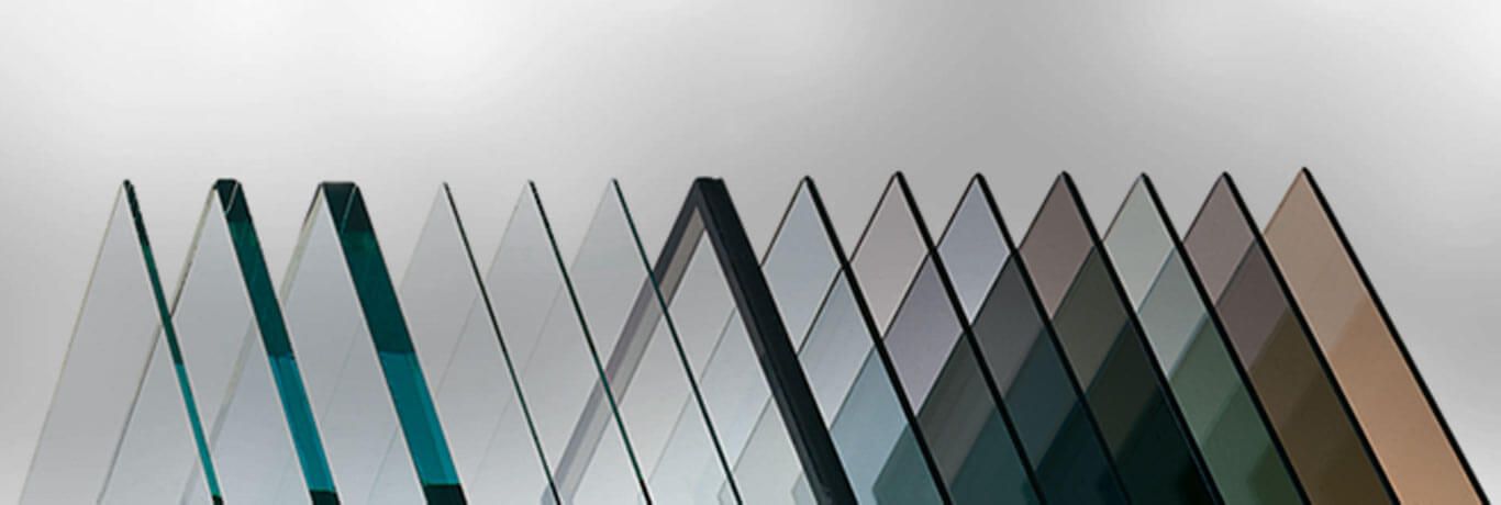 A row of various tinted glass panes, from clear to dark brown, against a light background.