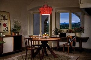 Cozy dining room with a red pendant light, wooden table, and scenic mountain view.
