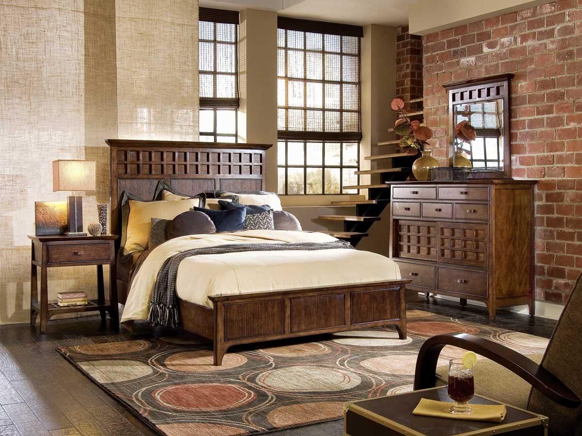 Bedroom with dark wood furniture, exposed brick wall, large windows, and spiral staircase.