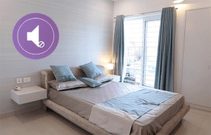 A modern bedroom with a neatly made bed, bedside tables, and a large window.