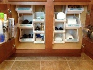 Organized bathroom cabinets with pull-out shelves holding toiletries and supplies.
