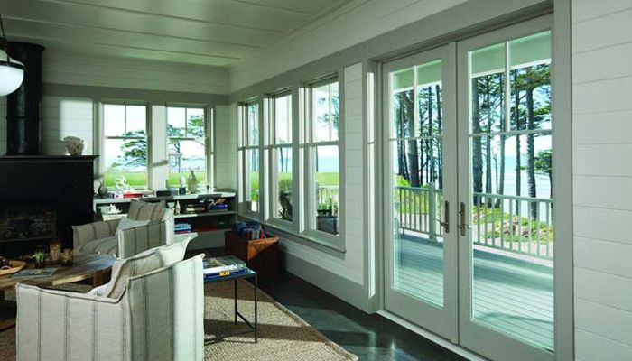 Spacious sunroom with large windows, glass doors, and scenic outdoor view.